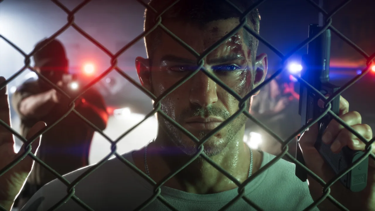 Jason Duval behind a chain-link fence, with police officers and flashing lights behind him in an official GTA 6 screenshot.